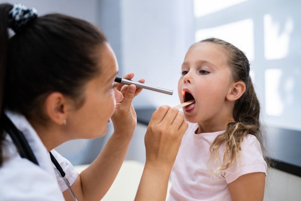 doctor looking in childs throat.