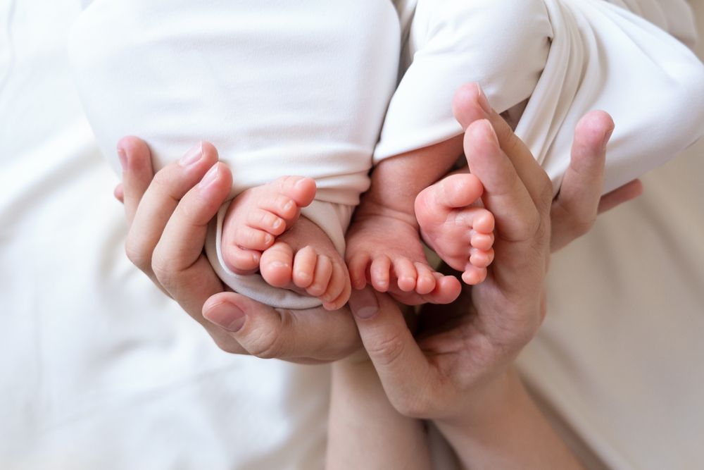 parent holding babies feet.