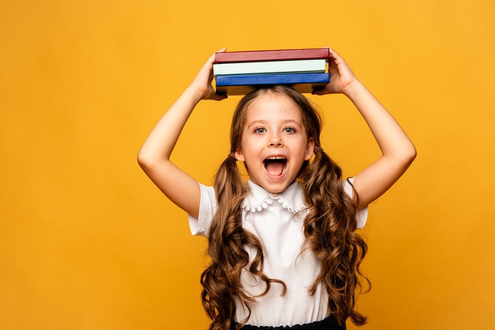 child holding school books.